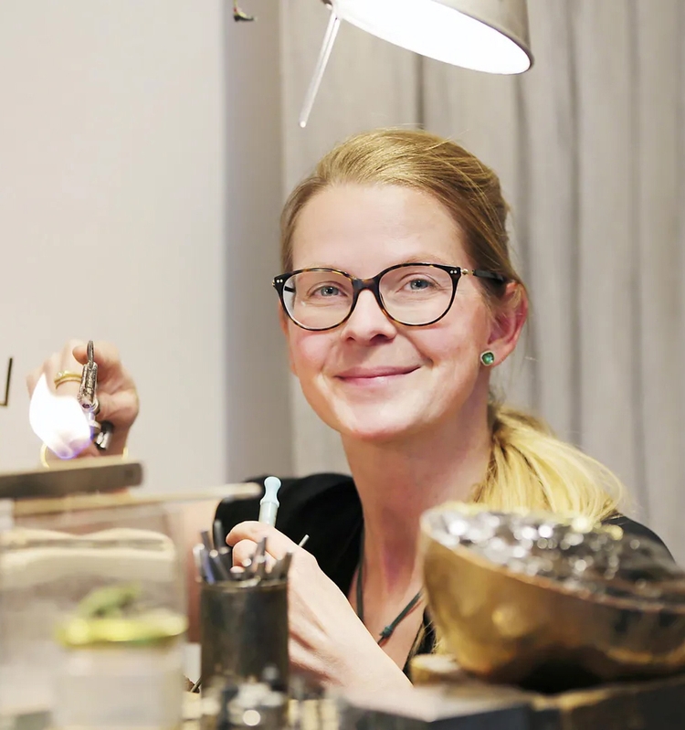 Ein Portraitfoto von Ulrike Lehmann bei der Arbeit in der Schmuck-Werkstatt.